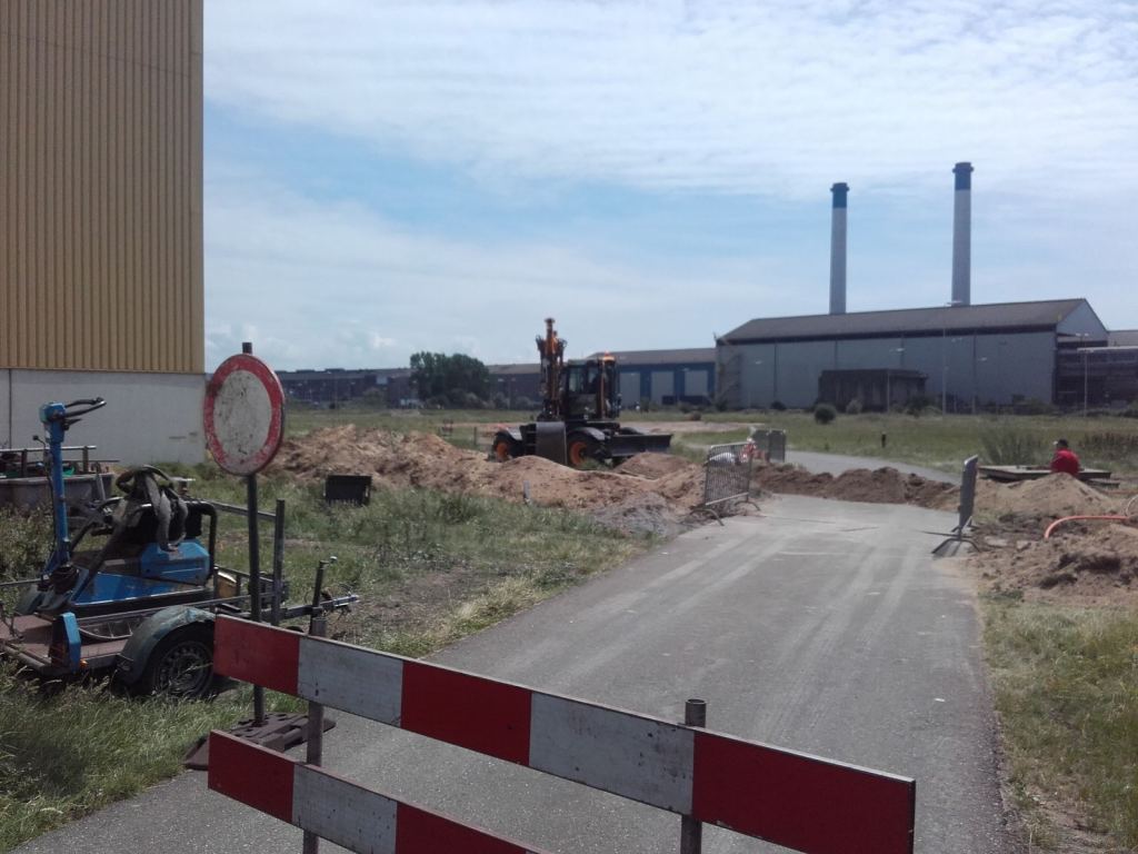 Afgezet werkterrein met zicht op de fabriek